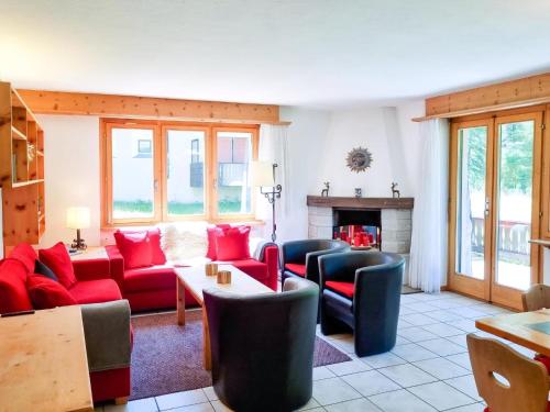 a living room with red furniture and a fireplace at Curtins16 in Pontresina