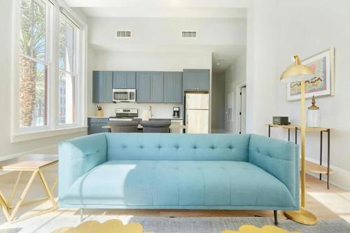 a blue couch in a living room with a kitchen at The Harlequin by AvantStay in New Orleans