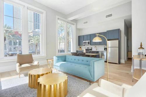 a living room with a blue couch and a kitchen at The Harlequin by AvantStay in New Orleans