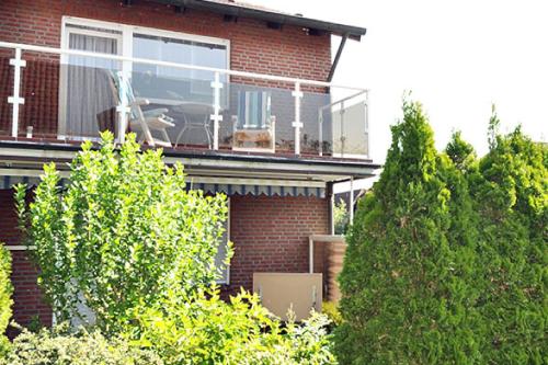a brick house with a balcony with a dog on it at Seestern in Horumersiel