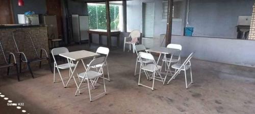 a group of tables and chairs in a room at Estância arco iris in Regente Feijó