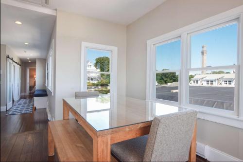 comedor con mesa de cristal y ventana en Renovated Oceanfront Penthouse, en Provincetown