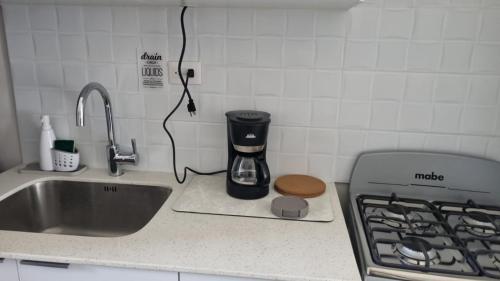 a kitchen counter with a coffee maker next to a sink at Cozy House! San Miguel in San Miguel