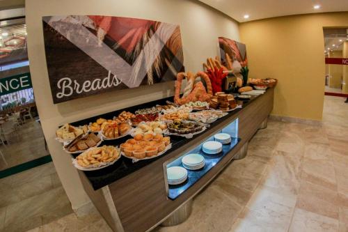 uma linha de bufê com diferentes tipos de comida em exposição em Emotions by Hodelpa Puerto Plata em San Felipe de Puerto Plata