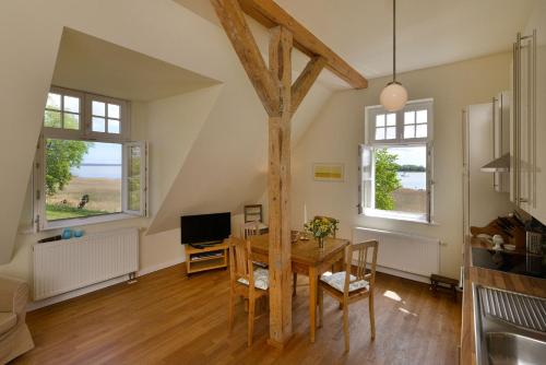 a dining room with a table and two windows at Wohnung Im Zweiten Obergeschoss Des Gutshauses in Neuenkirchen
