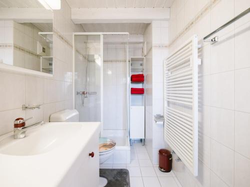 a white bathroom with a sink and a shower at Apartment Steamboat Suite in See- und Bergnähe, 4 Gäste, Balkon mit Aussicht in Faulensee