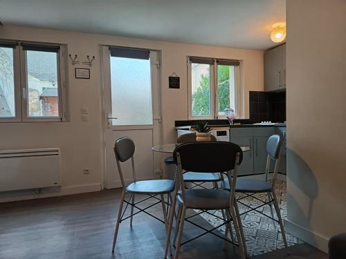 a kitchen and dining room with a table and chairs at Charmant petit logement in Bayeux
