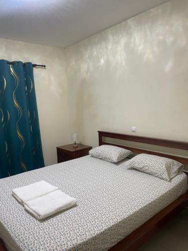 a bedroom with a bed with two towels on it at Constança Retreat in Mindelo