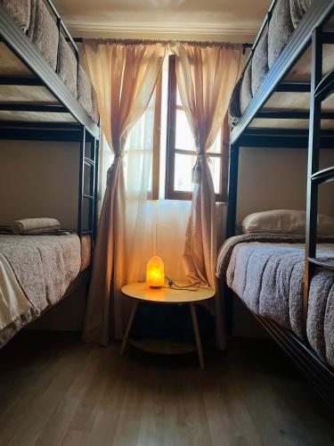 a room with two bunk beds and a table with a candle at Cabañas Piedra Viva 2 in San Pedro de Atacama