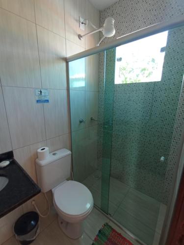 a bathroom with a toilet and a glass shower at Estadia cipó in Serra do Cipo