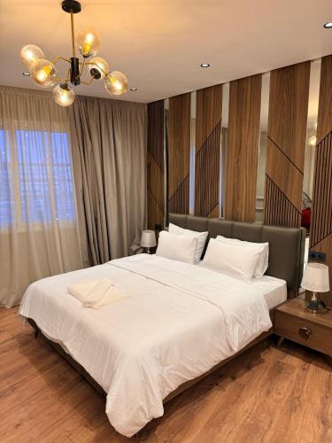 a bedroom with a large white bed and a chandelier at Suite Bahiya 15 in Fez