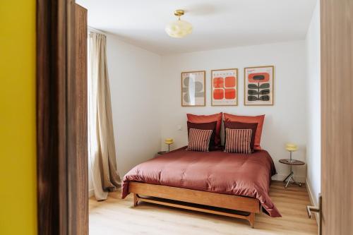 a bedroom with a bed with red sheets and pillows at Appartement centre village Tavel in Tavel