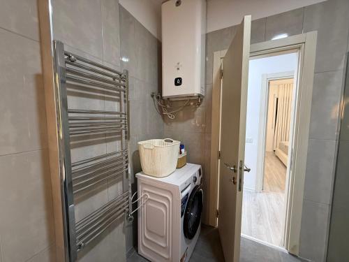 een wasmachine en droger in een badkamer met een deur bij Modern 2BR Near City Ring & Main Road Access in Tirana