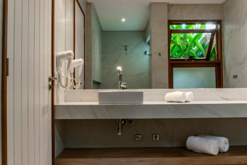 a bathroom with a sink and a mirror at Hotel Paraiso do Morro in Arraial d'Ajuda