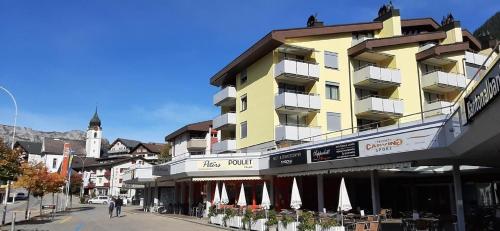 a yellow building on the side of a street at Rothorn Center A 1Og Schöpfer in Sörenberg