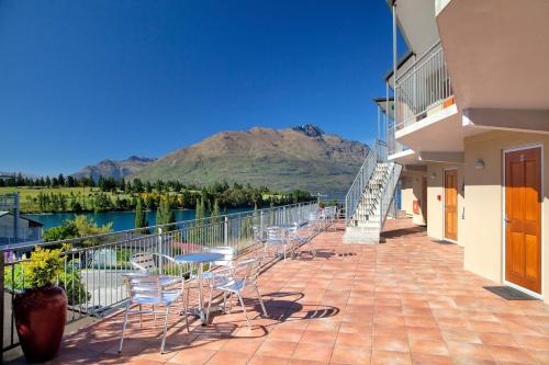 a balcony with chairs and a view of a mountain at Alexis Motel & Apartments in Queenstown