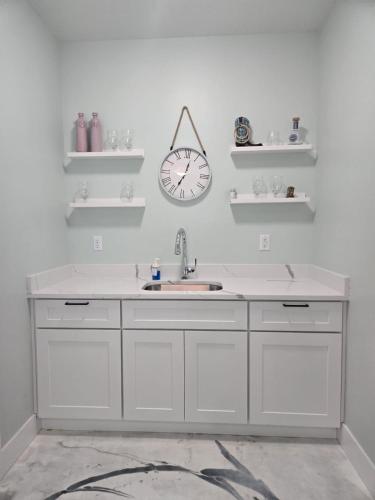 a kitchen with a sink and a clock on the wall at The Backwoods Paradise in Logan