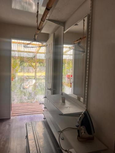 a bathroom with a large mirror and a window at Hiariki Lodge in Hiva Oa