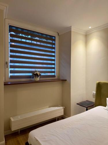 1 dormitorio con ventana, radiador y cama en eco Appartements Reichel, en Baden-Baden