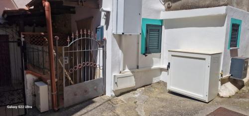 einen Eingang zu einem weißen Gebäude mit einem Tor in der Unterkunft Casa Marigé in San Nicola Arcella