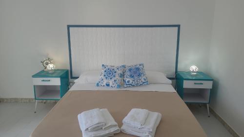 a bed with two nightstands and towels on it at Casa Marigé in San Nicola Arcella