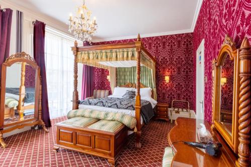a bedroom with a canopy bed and red walls at Hubert House Guesthouse in Dover