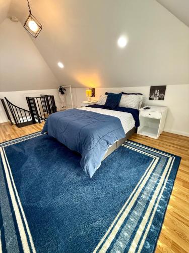 北卑尔根NYC Holiday Stay in Stylish Loft 6 Miles from Times Square的卧室里有一张大床和一块蓝色地毯