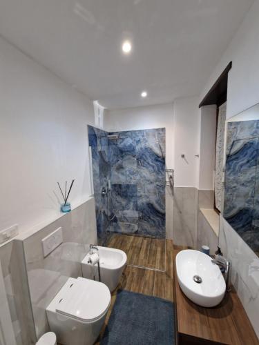 Un baño con inodoro, lavabo y ducha. en Beki's apartment, en Alba