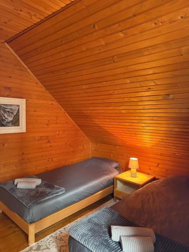 a bedroom with two beds in a wooden room at Vila Rosa Kolasin in Kolašin