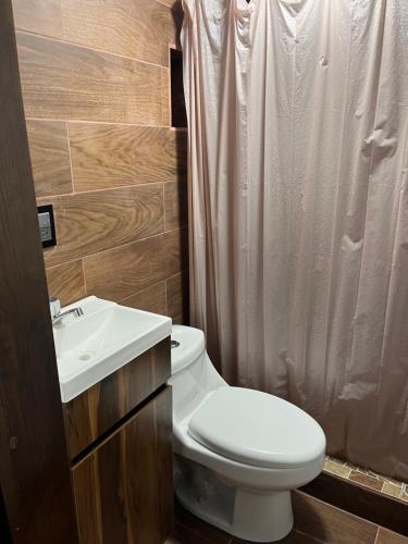 Un baño con un inodoro blanco y un lavabo. en Stone laja, en Guadalajara