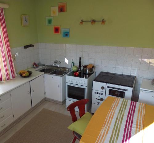 a kitchen with a stove and a sink and a table at Ferienwohnung 2 Ferienhaus Gassner In Navis in Navis
