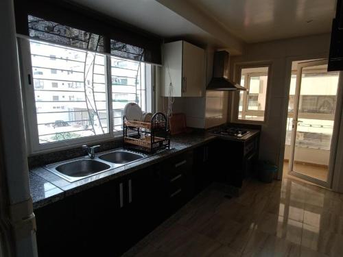 a kitchen with a sink and a stove and a window at Luxury Prestigia Fes - 7 Appartements - Vue Parc ou Quartier in Fès