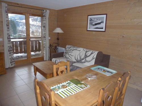 una sala de estar con una mesa y un sofá en Le Hameau des Neiges, en Demi-Quartier