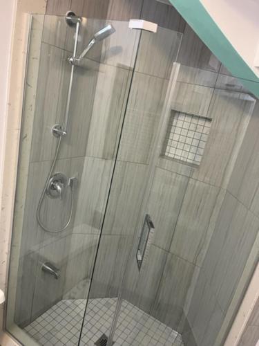 a shower with a glass door with a toilet at bachelor basement apartment with private kitchenette, washroom, and parking in Toronto