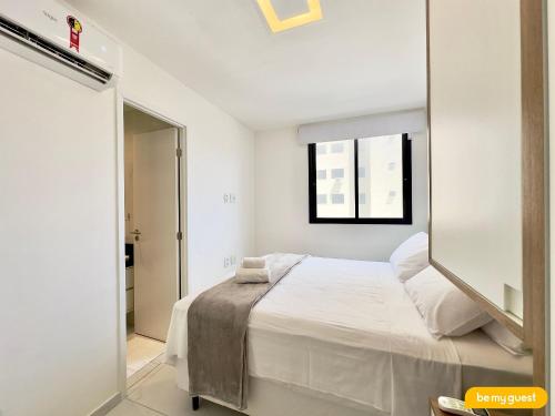 ein weißes Schlafzimmer mit einem Bett und einem Spiegel in der Unterkunft JSmart Dom in Fortaleza
