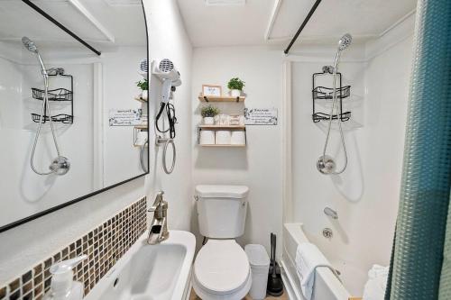 une salle de bain avec toilettes, lavabo et miroir dans l'établissement Juanita Bay Cottages B2, à Kirkland