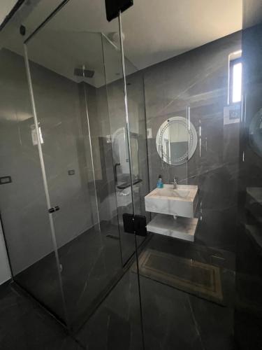 une salle de bains avec douche, lavabo et miroir dans l'établissement Villa Ohaio, à Amman