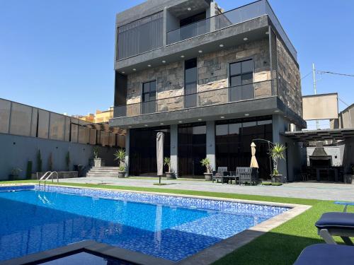 une maison avec piscine devant un immeuble dans l'établissement Villa Ohaio, à Amman