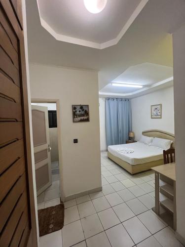 a bedroom with a bed and a table and a door at Hôtel chez Marie Oyouma in Port-Gentil