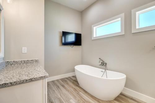 a white bathroom with a tub and a tv at Seven Palms in Rockport