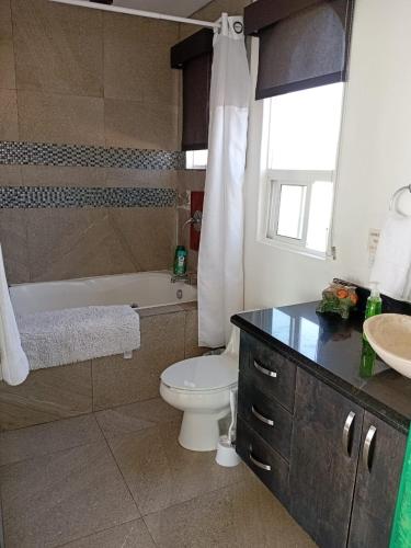 a bathroom with a tub and a toilet and a sink at Casa Mar Verde - Oceanfront Penthouse - Pool & Jacuzzi in Primo Tapia