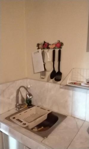 a kitchen counter with a sink and utensils on a shelf at Villa Naylamp Loft 1 playa Pocitas in Máncora