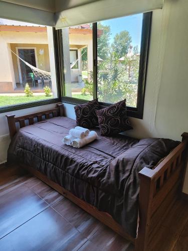 a bed in a room with a large window at Cabaña premium! in Villa Anizacate