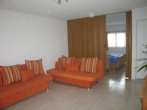 a living room with two orange couches in a room at Rehalp Osten in Bischofszell