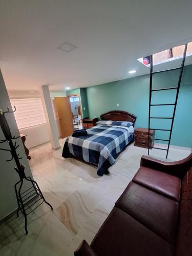 une chambre avec un lit, un canapé et une chaise dans l'établissement La última parada del Alauseño, à Alausí