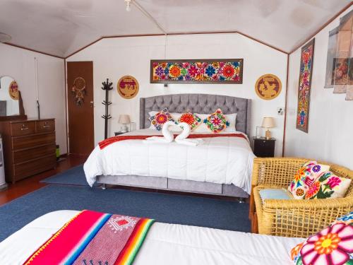 une chambre avec un grand lit blanc avec des oreillers colorés dans l'établissement Uros Titicaca Floating Bed, à Puno