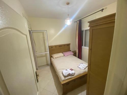 Un dormitorio pequeño con una cama y un espejo. en Gzenaya, en Tánger