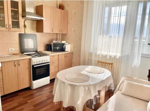 eine kleine Küche mit einem Tisch und einem Herd in der Unterkunft Затишна однокімнатна квартира Глеваха in Glevakha