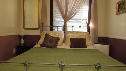 1 cama con 2 almohadas y 1 ventana en el dormitorio en The Historic Argo Hotel, en Crofton