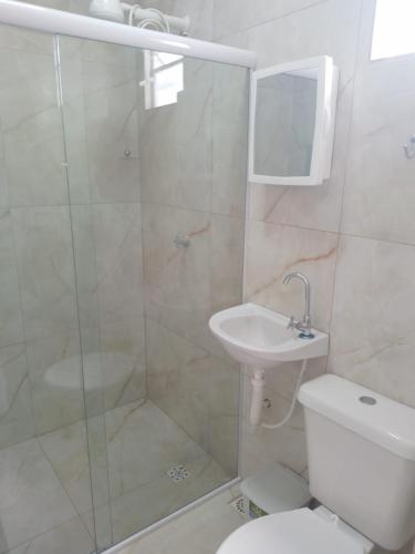 a bathroom with a shower and a toilet and a sink at Almar Maragogi in Maragogi